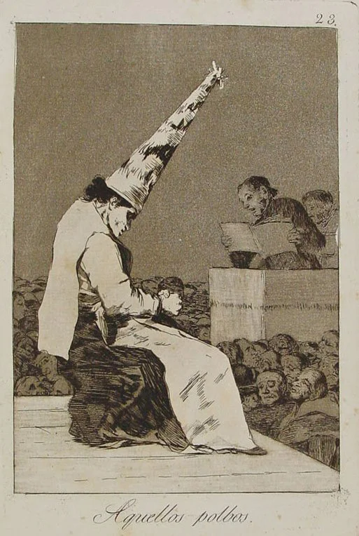 Etching of a seated figure wearing a tall pointed hat before officials at a desk, with a crowd of fa