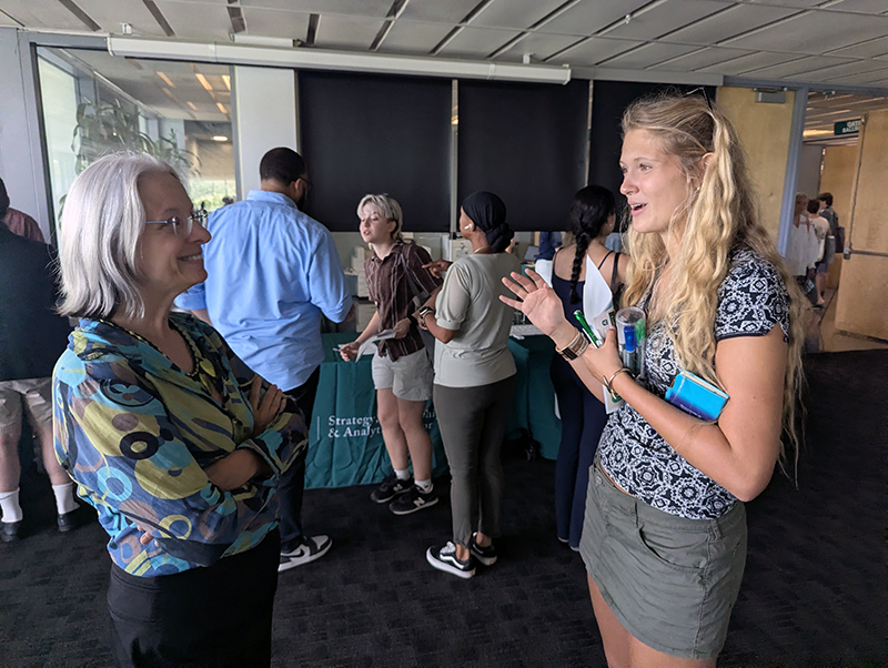 Faculty member at student chat at SLAM table at Open House