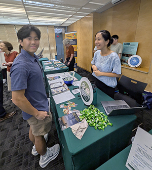 Student chats with faculty member at Asian Studies table at Open House