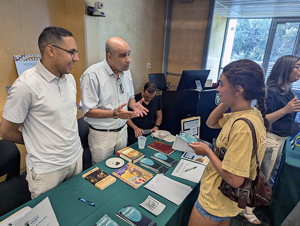 Middle East and North African Studies faculty members chat with student at Open House