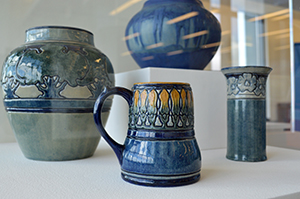 A collection of Newcomb Pottery displays common motifs found in Louisiana like oak trees and Spanish